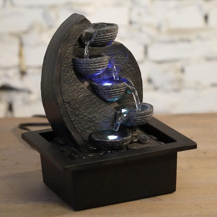 Джерело води Zen'Light Zimmerbrunnen V2 з 4 рівнями, імітація натурального каменю та кольоровим LED-підсвічуванням. Сучасна декор для столу, ідеально для медитації та релаксації. Висота 26 см. Унікальний дизайн.