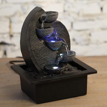 Джерело води Zen'Light Zimmerbrunnen V2 з 4 рівнями, імітація натурального каменю та кольоровим LED-підсвічуванням. Сучасна декор для столу, ідеально для медитації та релаксації. Висота 26 см. Унікальний дизайн.